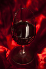 Glass of wine on red silk
