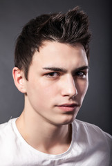 Obraz premium Handsome face of a young man on grey