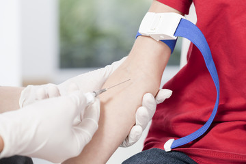 Nurse's hands taking blood sample