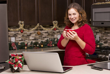 woman with laptop in Christmas kitchen