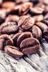 Coffee beans  on grunge wooden background.Macro