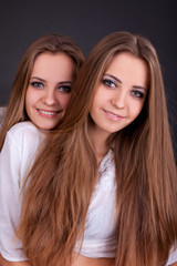 Two beautiful girls twins, isolated on black