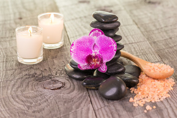 Orchid, bath salt and candles on weathered deck
