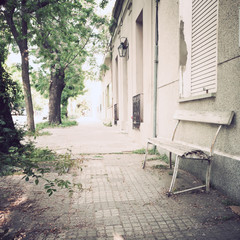 Fototapeta na wymiar Vintage bench in a tranquil sidewalk