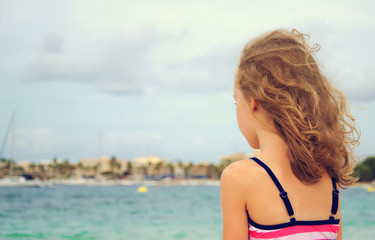 Naklejka premium Sad little girl looking at the sea.