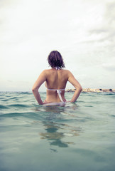 Obraz premium Young woman sunbathes in the sea. Vintage effect.