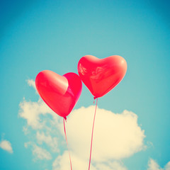 Fototapeta na wymiar Two red heart-shaped balloons