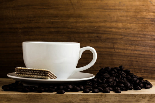warm cup of coffee with bean on wood background