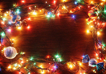 Obraz premium Christmas garlands of lamps on a wooden background.
