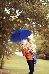 Happy mother and baby having fun in autumn day