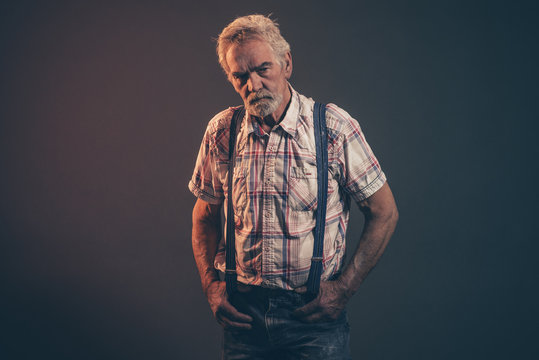 Characteristic senior man with gray hair and beard wearing check