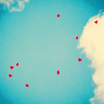 Bunch of heart-shaped balloons flying away