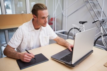 Fototapeta premium Man using graphics tablet to do work