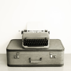 Vintage typewriter over suitcase