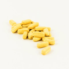 Yellow pills isolated on white background.