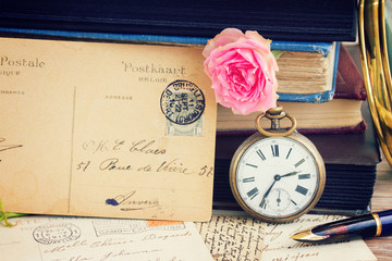 antique clock on old  books and letters background