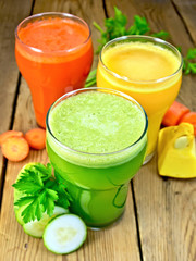 Juice vegetable in three glassfuls with vegetables on table