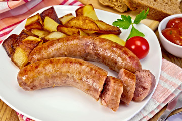 Sausages pork fried with potatoes in plate on board