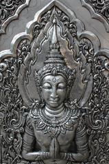 Fototapeta na wymiar Deva silver carving art on temple wall.