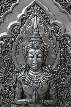 Deva silver carving art on temple wall.