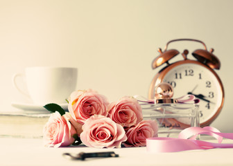 Pink roses, vintage alarm clock and various objects