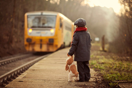 Adorable boy on a railway station, waiting for the train