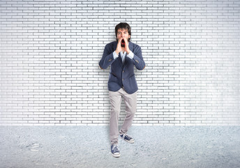 Handsome man shouting over textured background