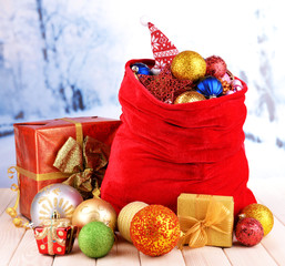Red bag with Christmas toys on winter background