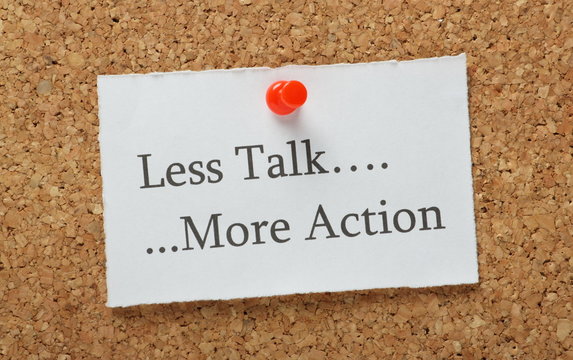 Less Talk, More Action Reminder on a cork notice board