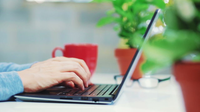 Young man working on laptop and drinking coffee