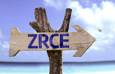 Zrce wooden sign with a beach on background