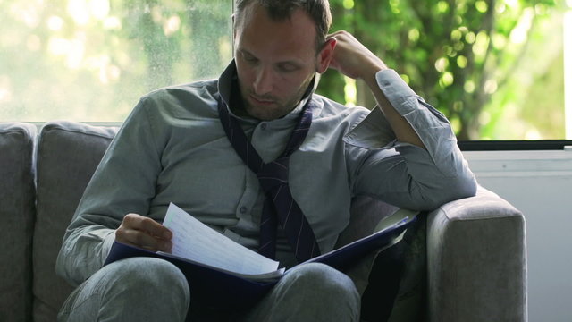 Businessman working on documents at home, steadycam shot