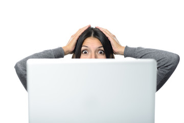 Frau schaut überrascht mit offenen Augen auf Computer