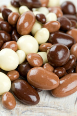 chocolate covered nuts and raisins on wooden surface