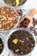 assortment of dry tea in glass bowls on wooden surface