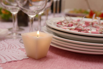 Buffet table with dishware and candle waiting for guests