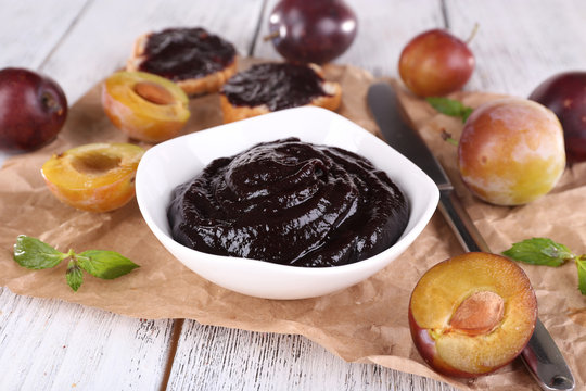 Plum jam, slices of bread with plum jam and fresh plums in