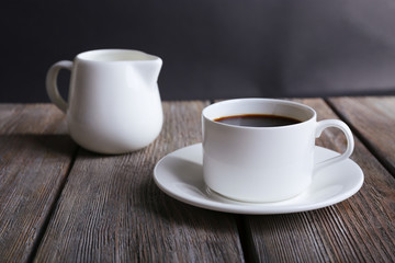 Cup of coffee and cream in milk jug