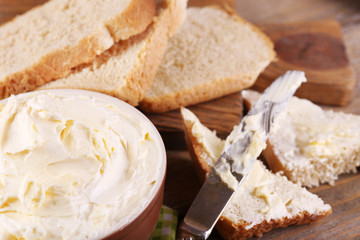 Fresh homemade butter in bowl and sliced bread,