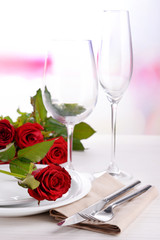 Table setting with red rose on plate