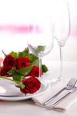 Table setting with red rose on plate