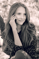 Young smiling girl talking on phone, black and white photo