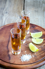 Glasses of tequila on the wooden board