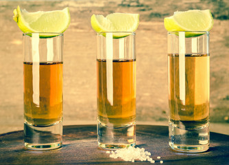 Glasses of tequila on the wooden board