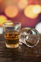 glass of rum whiskey over defocused lights background