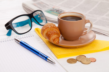 Coffee with croissant on a worktable