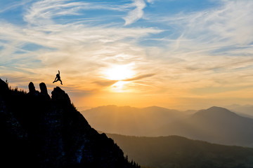 Naklejka premium hiker on the peak at sunset