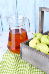 Ripe apples and juice in basket on table close-up
