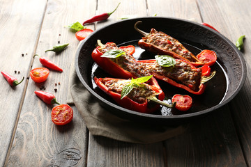 Delicious stuffed peppers in frying pan on table close-up