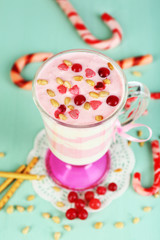 Cranberry milk dessert in glass  on color wooden background